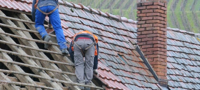 Roofing contractor inspecting an aging roof before replacement in Vancouver.
