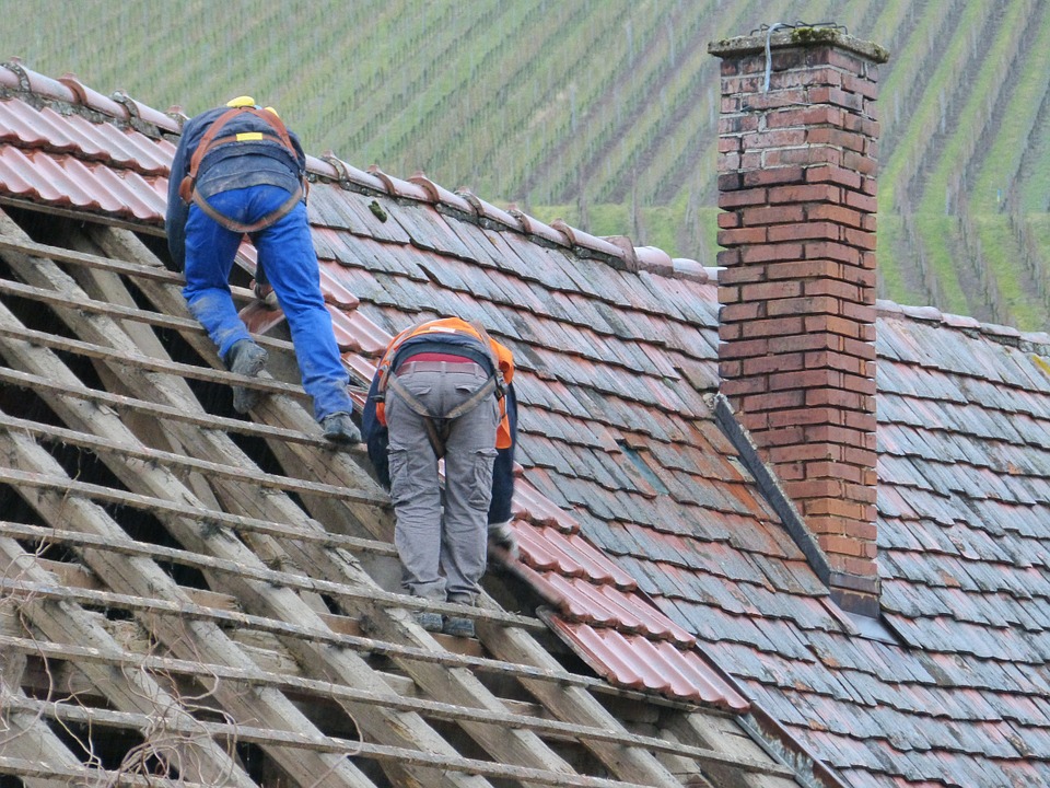 Roofing contractor inspecting an aging roof before replacement in Vancouver.