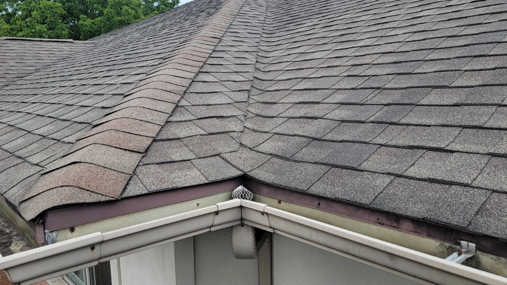 Roof drip edge damage with bent and corroded metal along the roof edge
